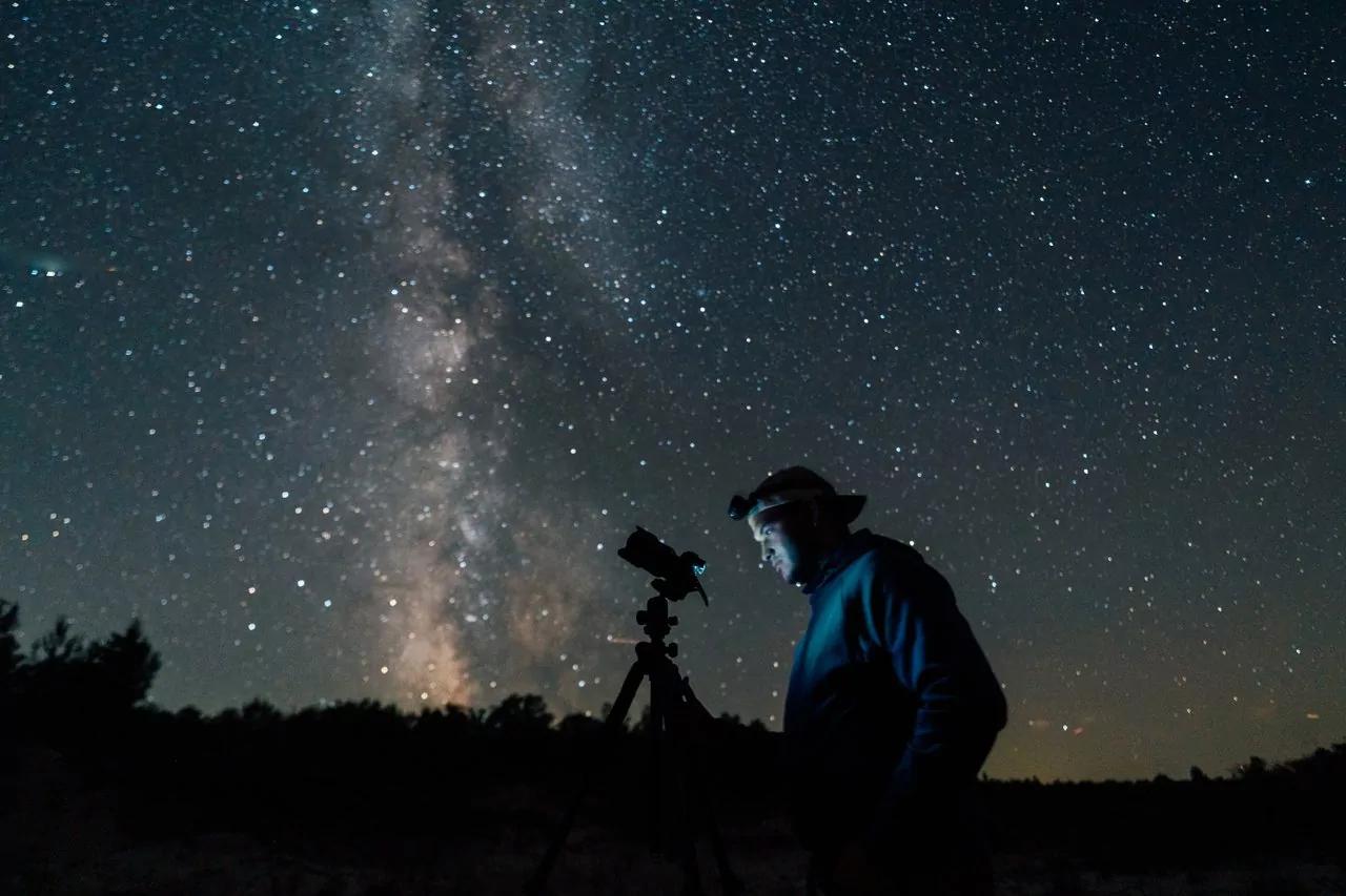 A man photographs the night sky at Harbor State Park in Alpena, MI