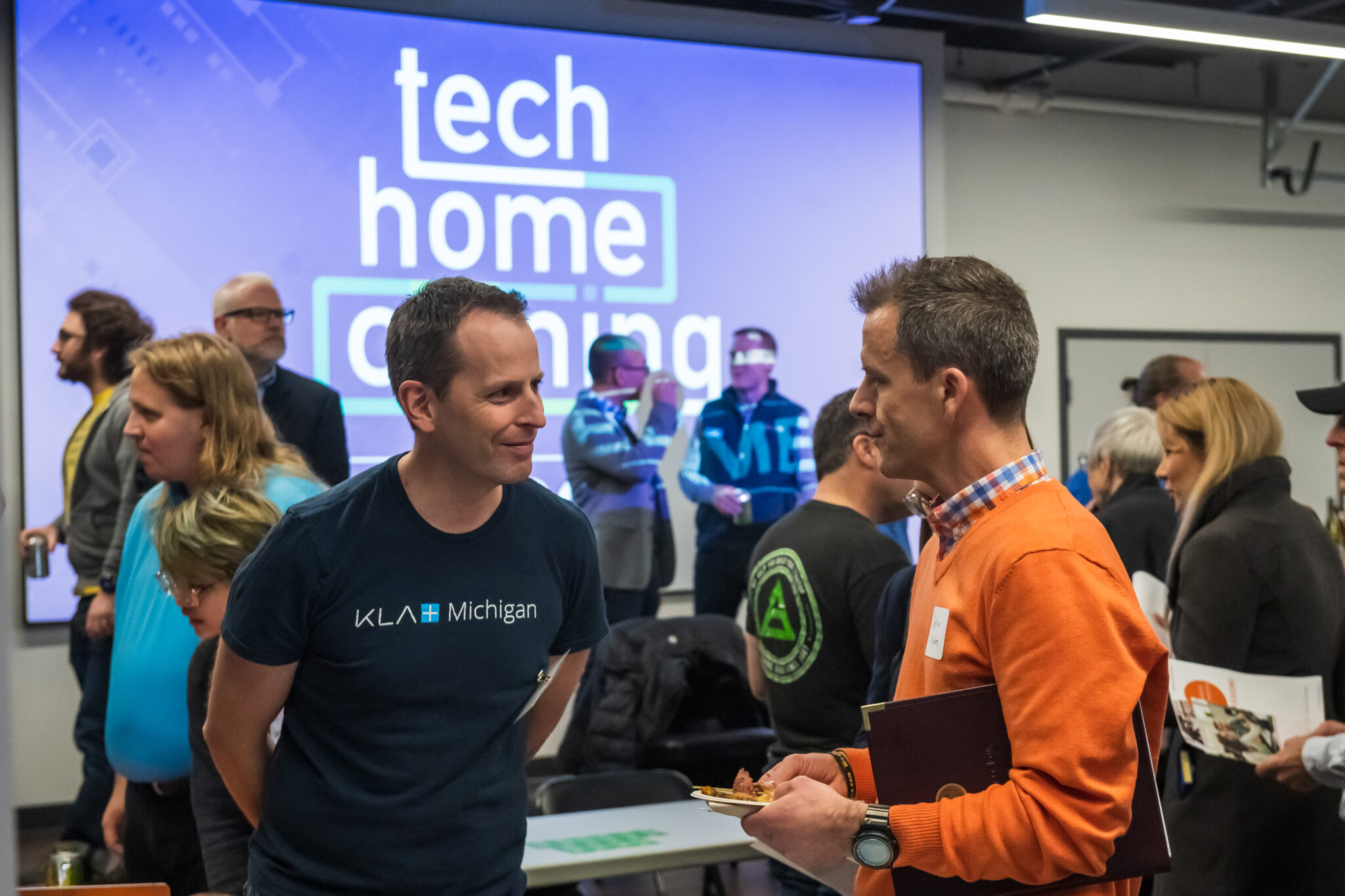 Two men networking at Tech homecoming event in Ann Arbor