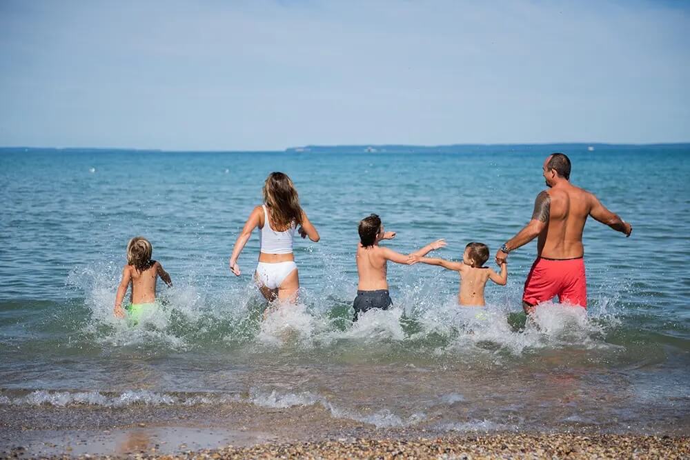 Family runs into stunning lake water in Traverse City.