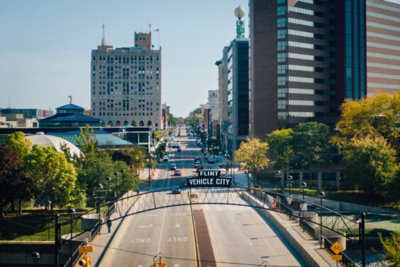 A sunny roadway divides buildings in Flint, Michigan.