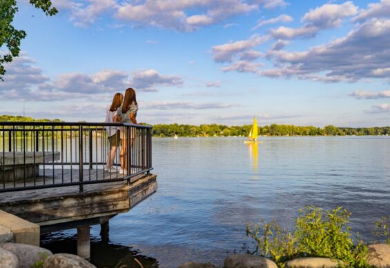 people overlooking a sailboat on Reed's lake in East Grand Rapids