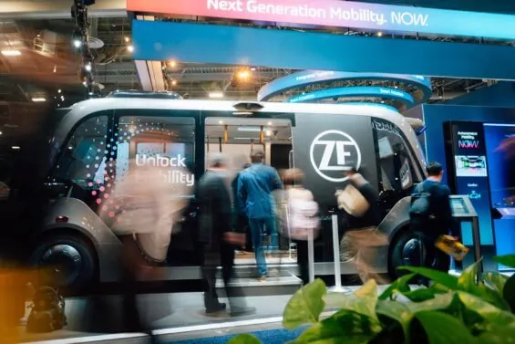Crowds walking in and out of ZF electric bus at convention.
