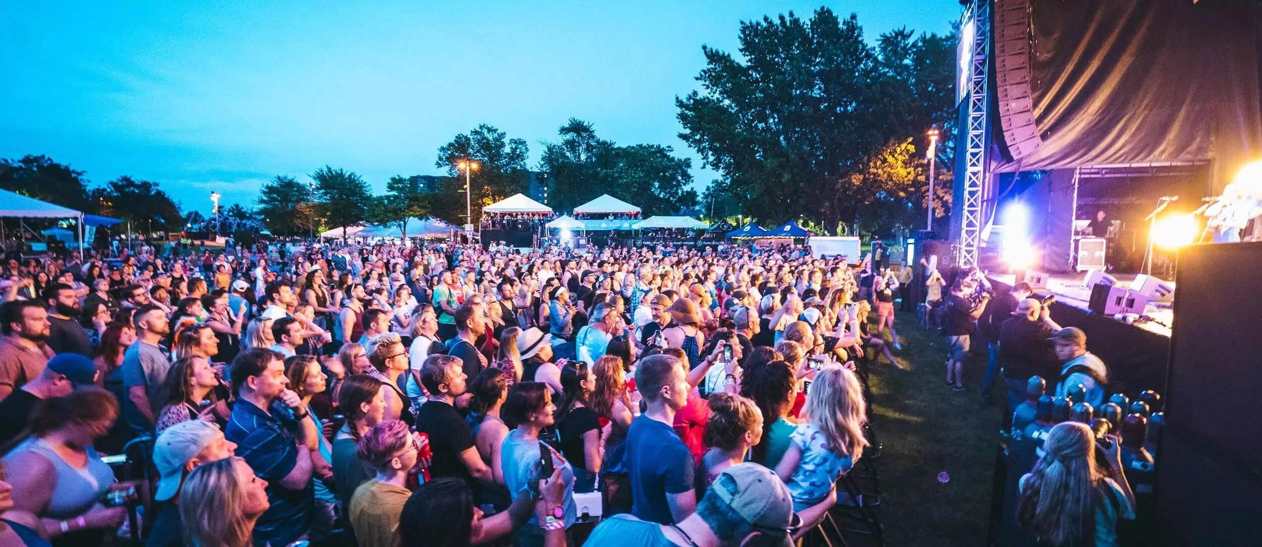 Crowd gathers for the Common Ground music fest in Lansing at night.