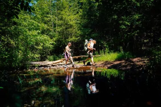 Father, mother and young daughter walk along a sunny trail path in Mount Lookout.