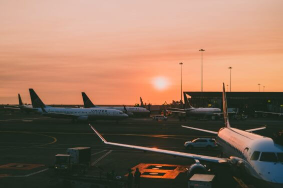 United Airlines airplanes docked at an airport at sunset.