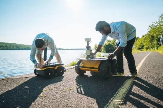 Two Michigan Technologicaal University students prepare their robots to operate outdoors.