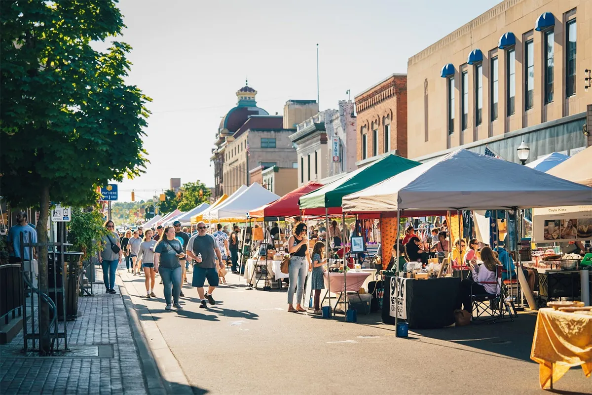Local residents amble through an open air market on a historic U.P. Main Street.