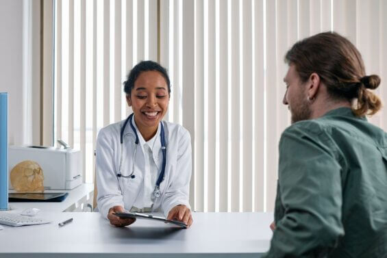 Doctor smiles while speaking with patient.
