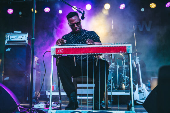 Musician plays the keyboard on stage at the Common Group Music Festival.