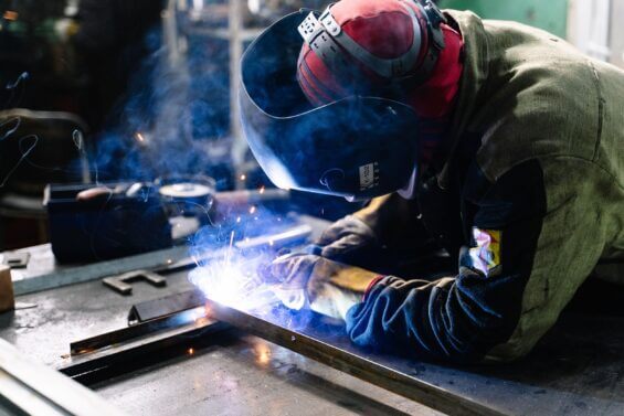 Man welding metal bars together at Great Lakes Sound & Vibration.